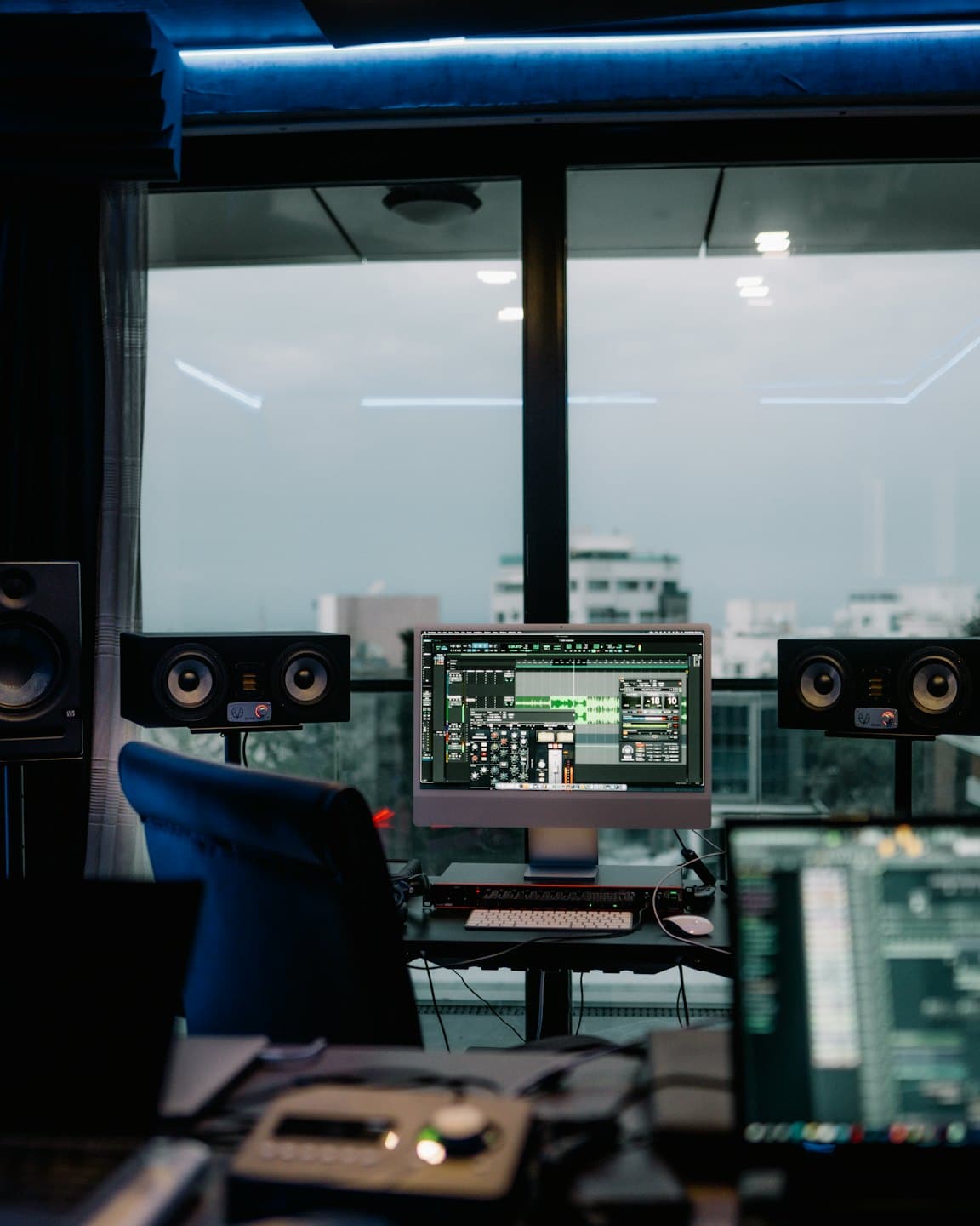 Geluidsstudio met DAW-software op het scherm en luidsprekers.